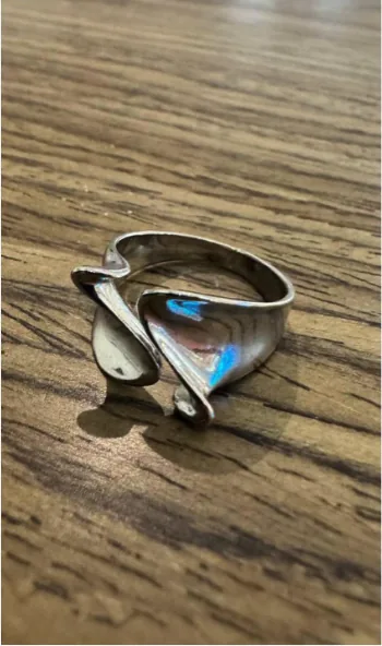 A ring photographed on a table with a phone